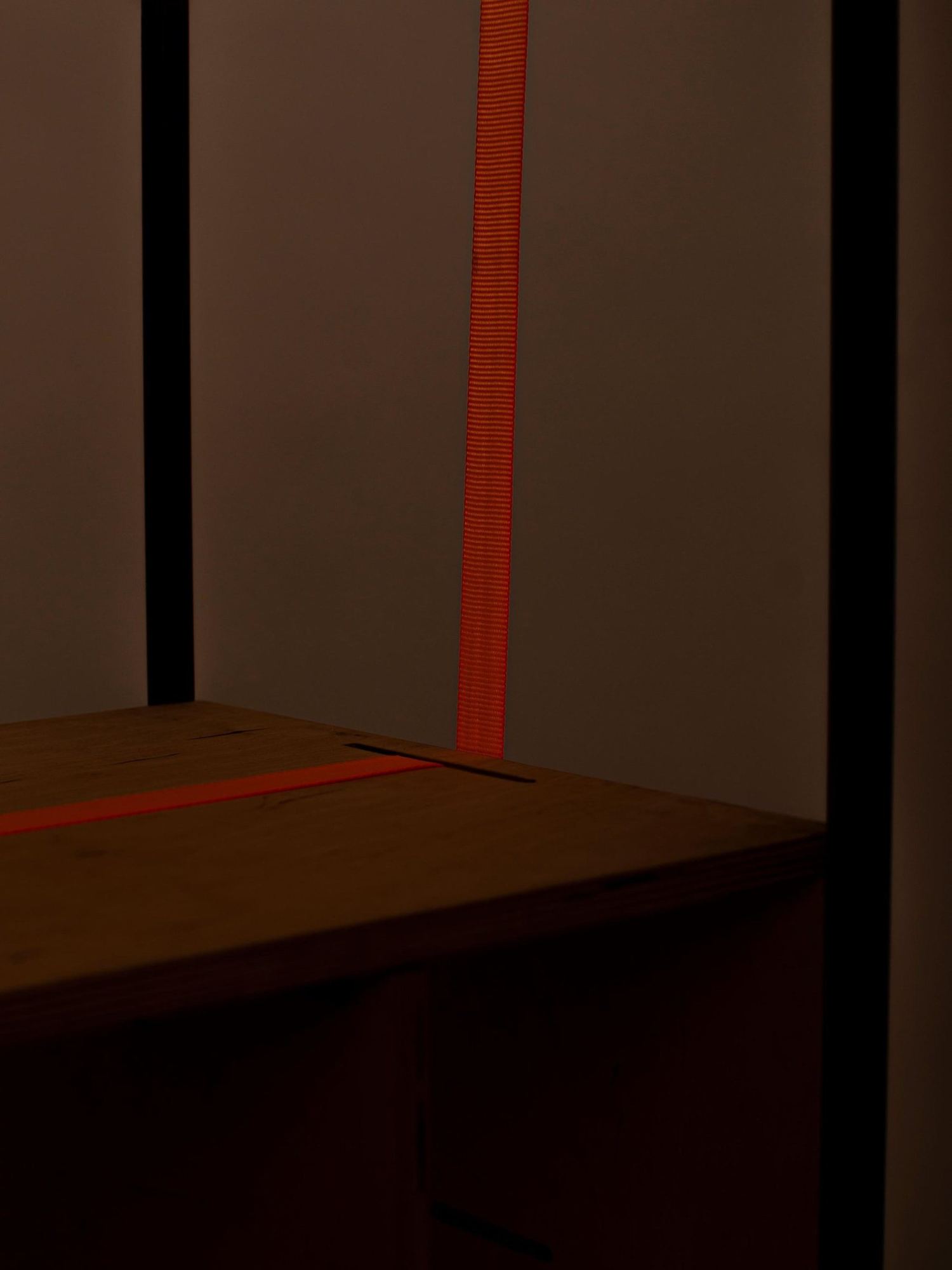 Detail: oranger Gurt an der Holzbox