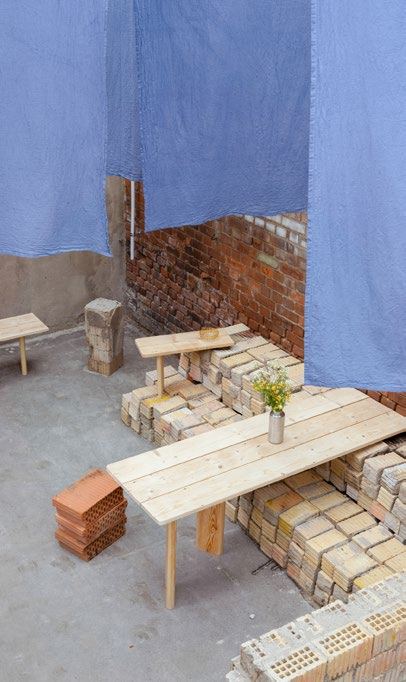 Blaue Textilien hängen von der Decke über dem Raum