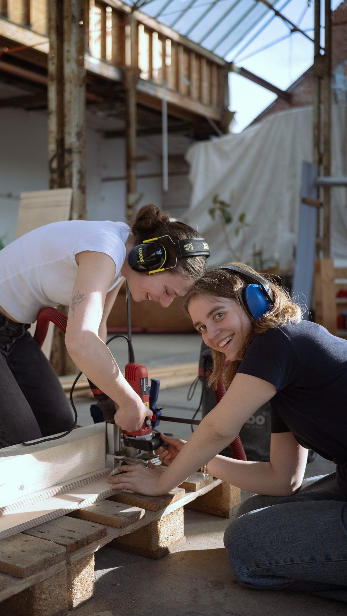 Zwei Studentinnen fräsen ein Holzbauteil