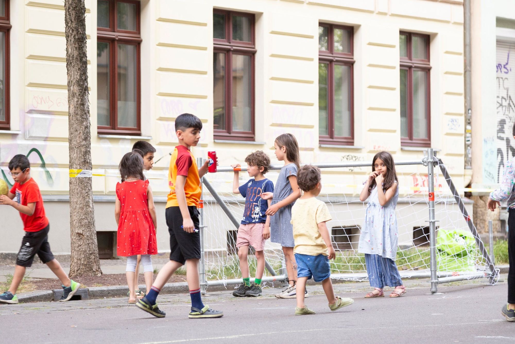 Kinder spielen vor einem Tor aus Gerüstrohren