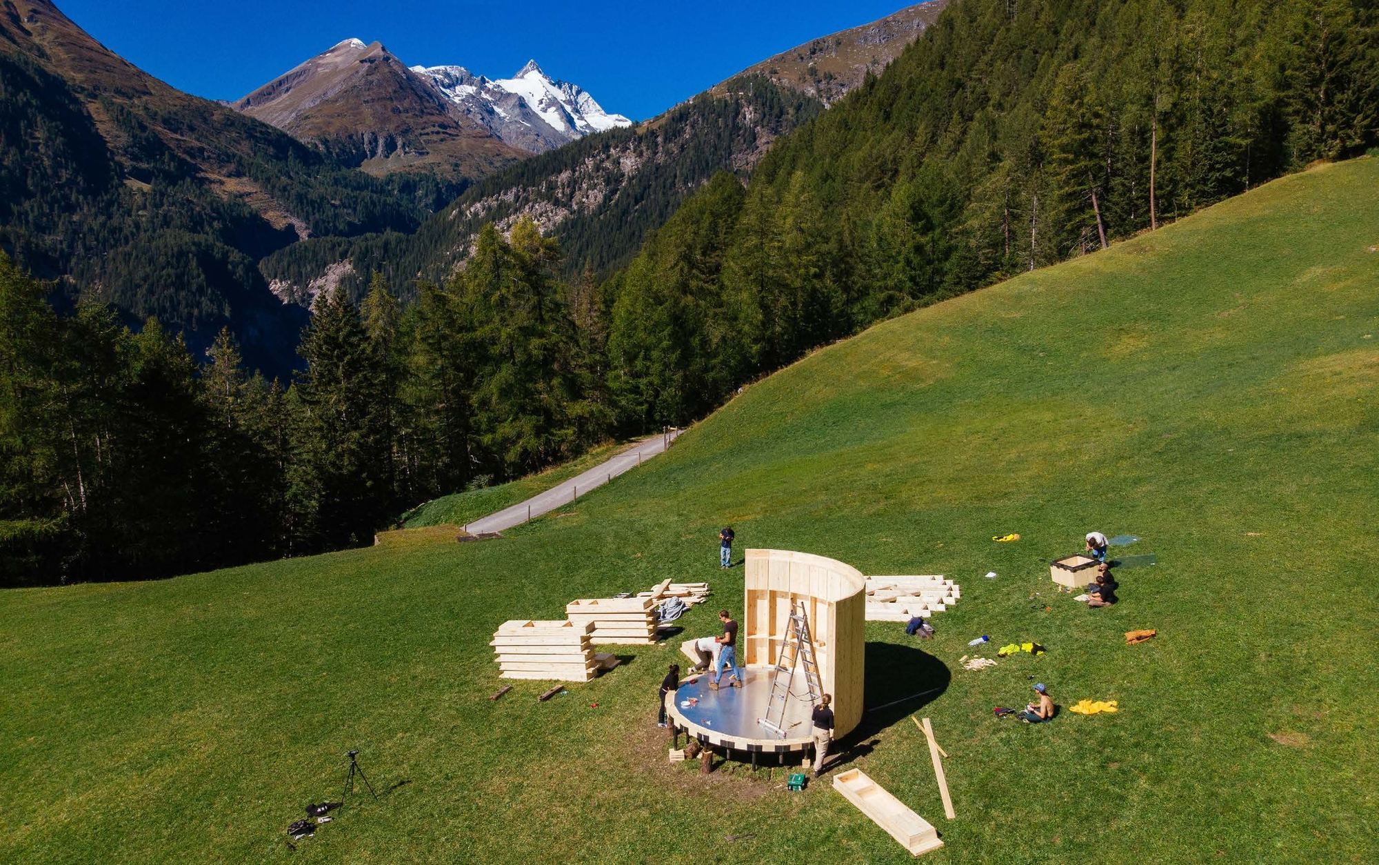 Aufbau einer Holzkonstruktion auf einer Alpenwiese